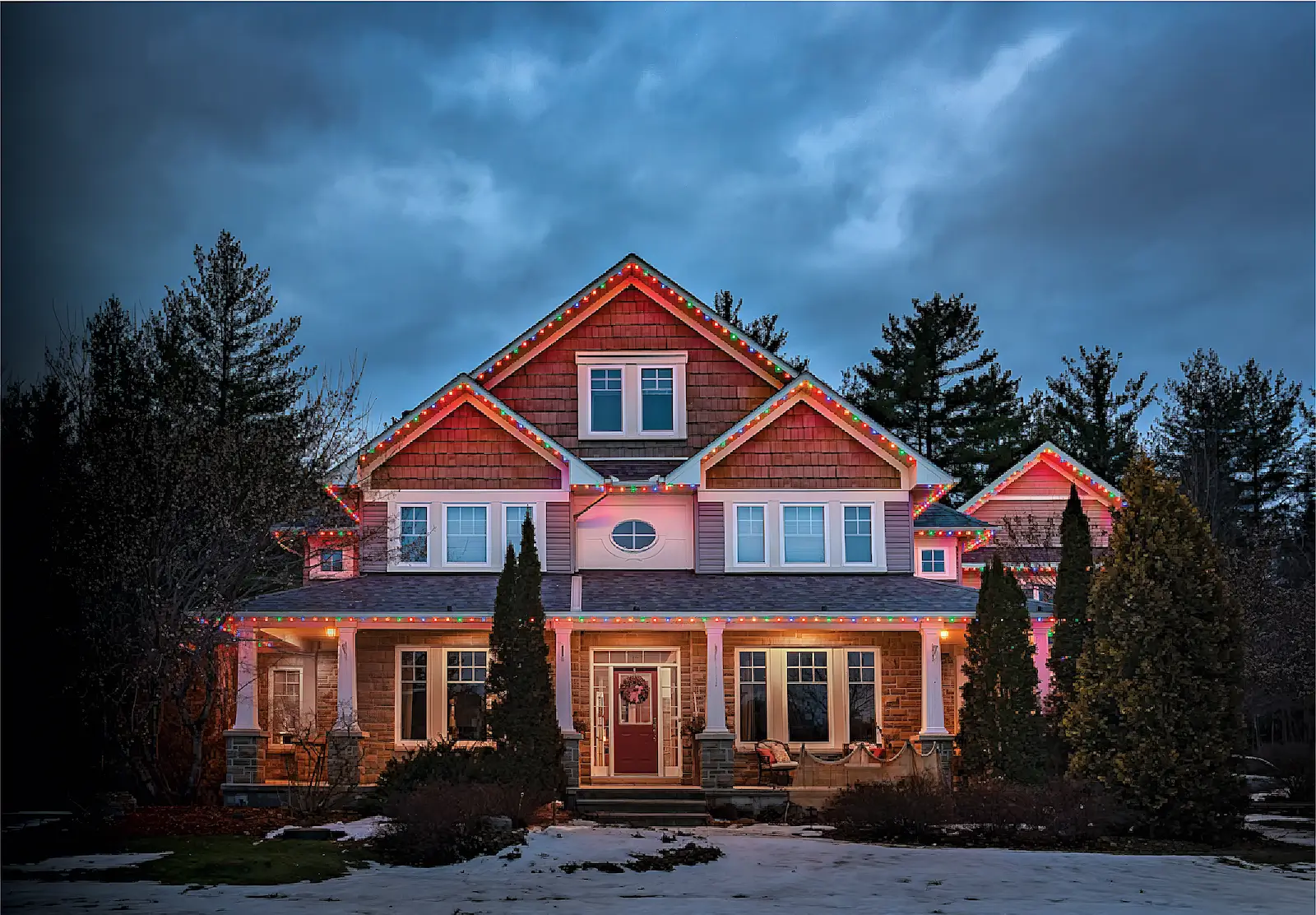 Two‑story home at dusk with warm lights